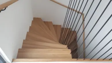 Moderní dřevěné schodiště s kovovým zábradlím.
