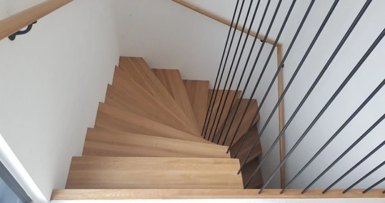 Moderní dřevěné schodiště s kovovým zábradlím.