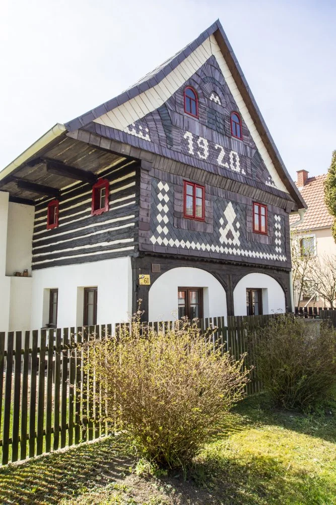 Historický dům z roku 1928 s dekorativním dřevěným obvodem.