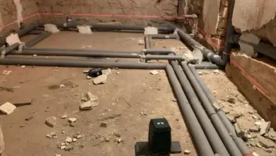 Instalace potrubí pro izolaci podlahy v koupelně před dlažbou.