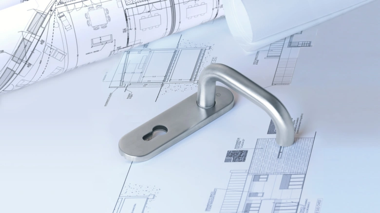 Rukojeť dveří na architektonických plánech pro montáž požárních dveří.