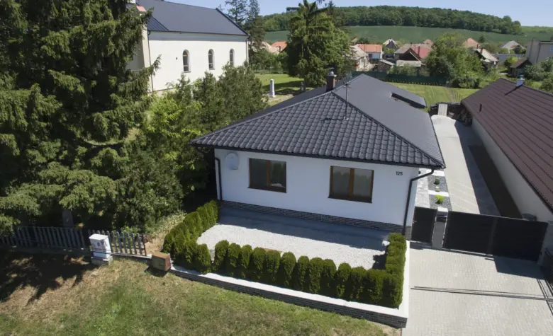 Bílý dům s valbovou střechou v české vesnici