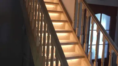 Dřevěné schodiště s podsvícenými stupni a dřevěným zábradlím.