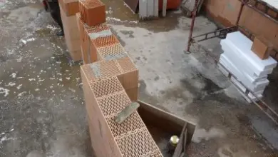 Řada nosných zdivových bloků na vlhkém betonu pro stavbu domu.