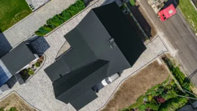 Vzdušný pohled na dům s tmavou střechou a dvorem.