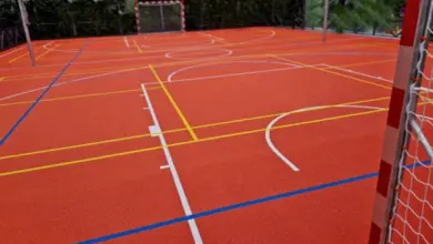 Vnitřní sportovní dvorec s červenou podlahou pro basketbal.