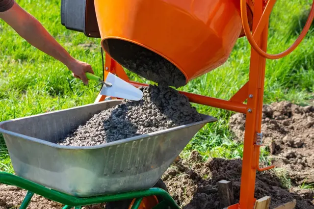 Lidá se beton z míchačky do vozíku ručně.
