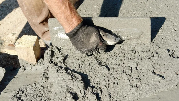 Ruční hladění čerstvého betonu špachtlí.