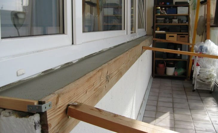 Čerstvý beton v bednění dřevěných forem na balkónu.