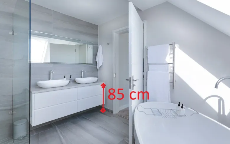 Bílá koupelna s umyvadlem na výšku 85 centimetrů od podlahy.