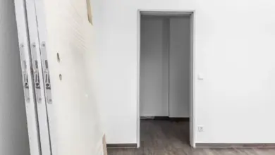 Nová bílá vnitřní dveře leží u zdi vedle otvoru pro montáž