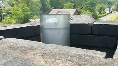 Otvor pro komín ve zdi s kovovou vložkou na venkově.