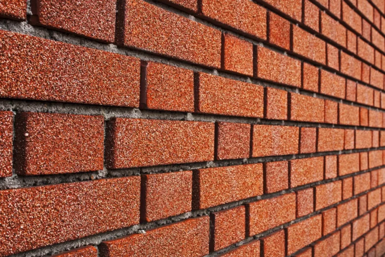 Detail červené cihlové fasády s viditelnými spárkami.