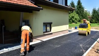 Práce na asfaltu před domem s parní válcovnou.