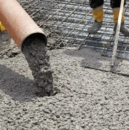 Zelený beton se nalévá na ocelovou mřížku při stavbě.