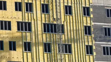 Žlutá minerální vlna na fasádě budovy při stavbě.