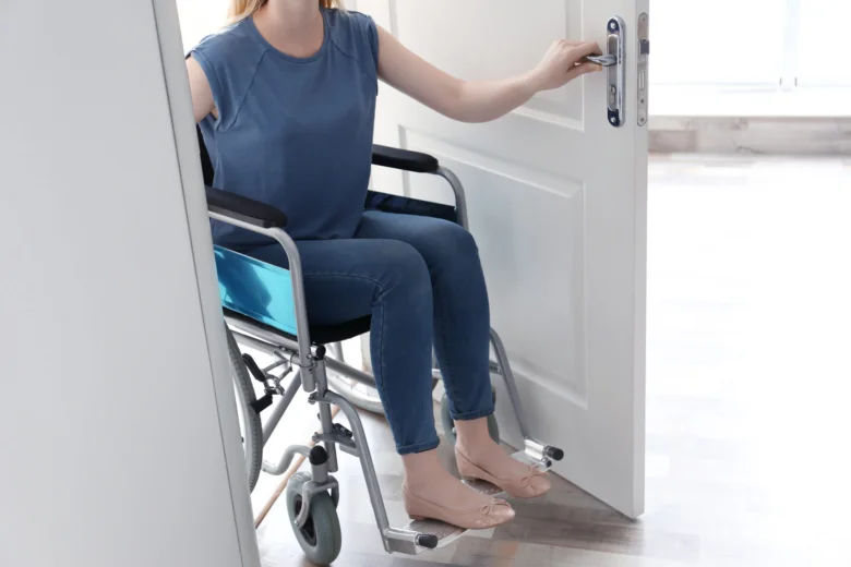 Person in wheelchair opening door