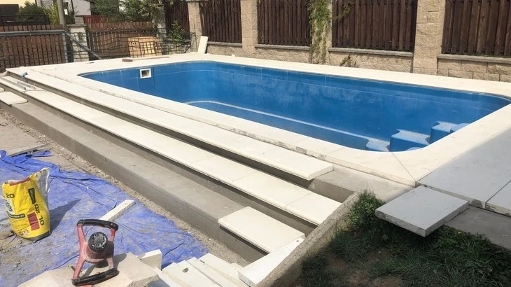 Stavba bazénu s dlažbou na lepidlo - nástroje a materiály uvnitř.