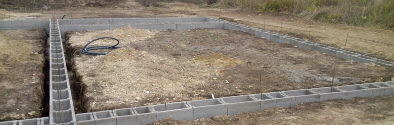 Základový pás z betonových bloků na staveništi.