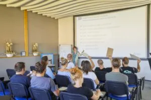 Skupina lidí poslouchá přednášku o stropních sádrokartonech.