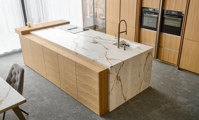 Moderní kuchyňská ostrov s mramorovou deskou a dřevěnými skříněmi.