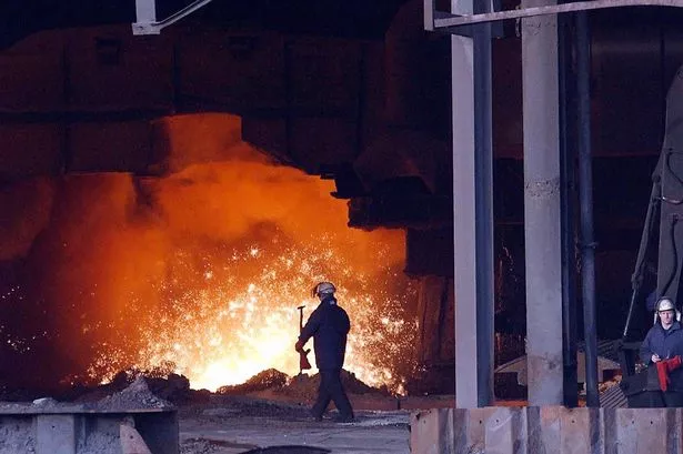 Ocelářský dělník u horké oceli při výrobě v vysoké peci