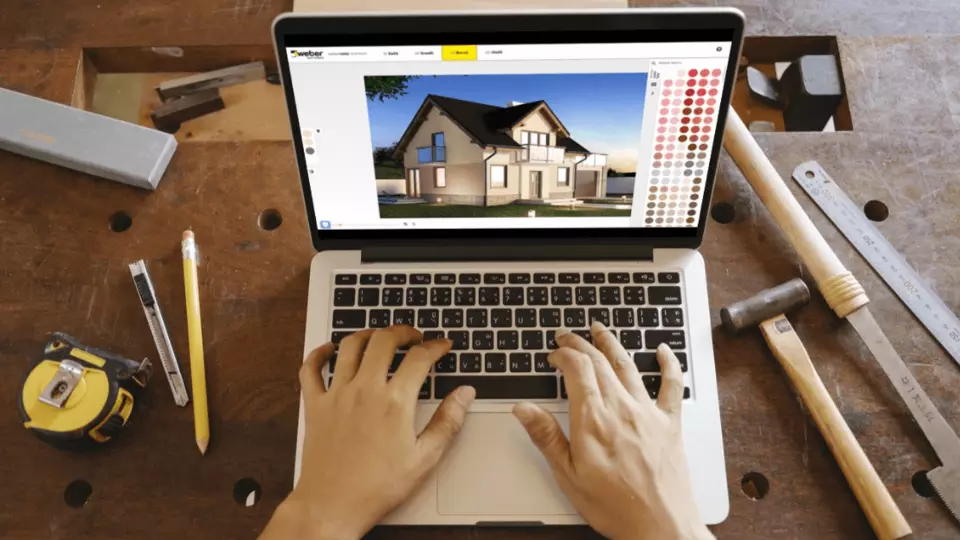 Ručník na laptopu s návrhem domu a paletou barev pro fasádu.