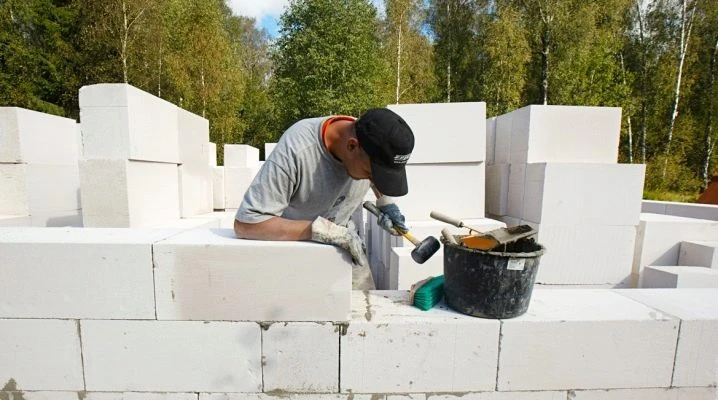Stavebník kladne plynosilikátové bloky na zdivo venku.