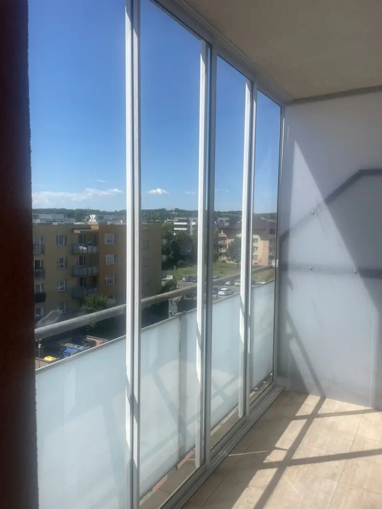 Moderní zasklení balkonu s posuvnými skleněnými panely.