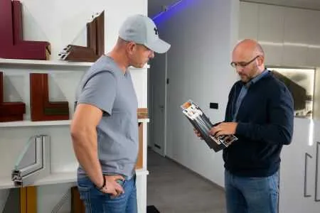 Muži zkoumají vzorky profilů plastových oken v obchodě.