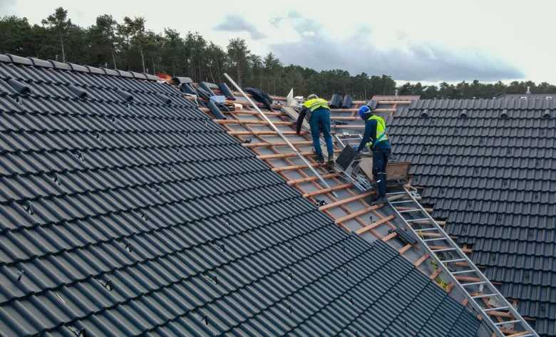 Práce na instalaci hřebene střechy s dřevěnými latkami.