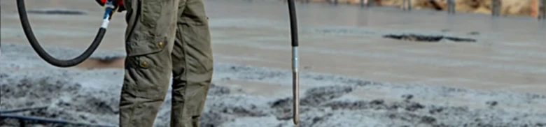 Person pouring concrete with hose