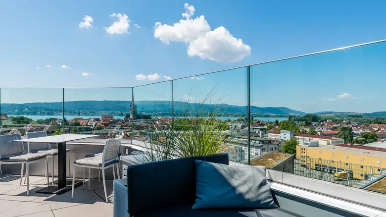 Moderní balkon s bezpečnostním skleněným zábradlím.