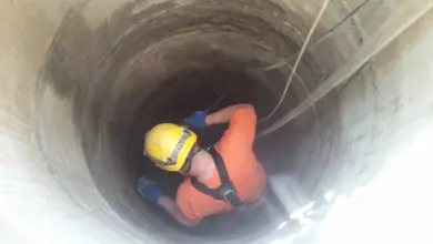 Pracovník v hluboké betonové studni nebo šachtě.