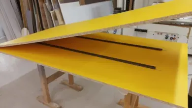 Žlutá laminátová deska na pilovém stole v dílně