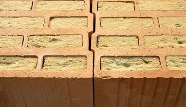 Červené cihly s izolačním materiálem uvnitř dutin.