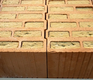 Červené cihly s izolačním materiálem uvnitř dutin.