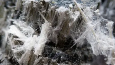 Bližší pohled na bílé vlákna azbestu v betonu.