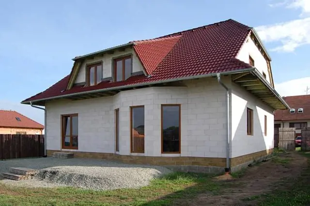 Nově postavený dům z porobetonu s červenou střechou.