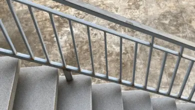 Schodiště s kovovým zábradlím a kamennými schody.