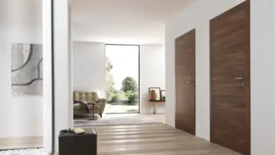 Moderní dřevěné dveře v chodbě vedoucí do obývacího pokoje.
