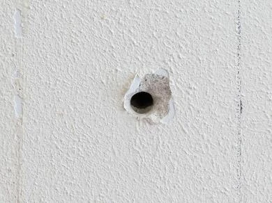 Díra ve stropním panelu připravená k opravě.