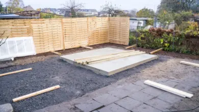Stavební místo zahradního domku s betonovou základnou a dřevěnými panely.