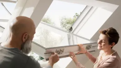 Muž a žena montují střešní okno Velux krok za krokem.