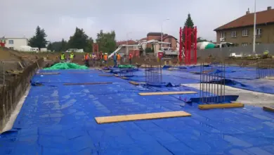 Modrá fólie chrání čerstvý beton před deštěm na staveništi.
