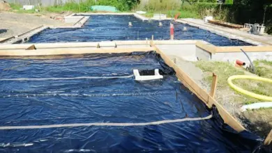 Černá hydroizolační fólie pod betonovou deskou na staveništi.