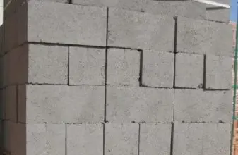 Skládané betonové cihly na dřevěné paletě pro stavební účely.