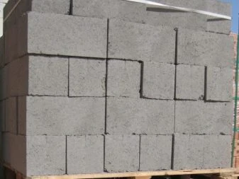 Skládané betonové cihly na dřevěné paletě pro stavební účely.