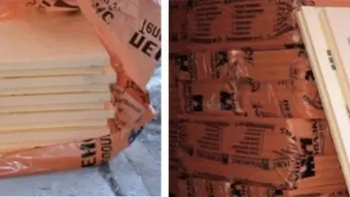Skládané desky penoplexu v oranžovém obalu s logem na zemi.