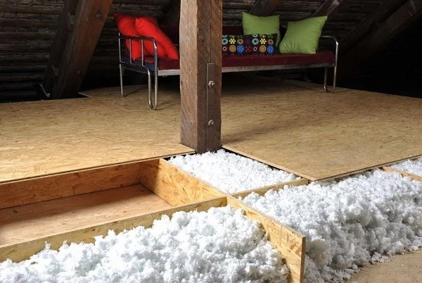 Izolační materiál pod dřevěnou podlahou v půdním prostoru.